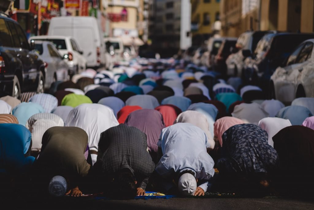 Blue Door Tangier Morocco Men praying in the streets during the holy month of Ramadan